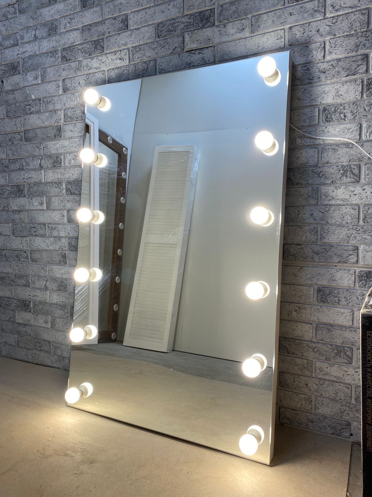 безрамное настенное гримерное зеркало с подсветкой лампочками по бокам
